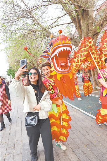 春節(jié)期間，江南路金龍巡游，吸引市民駐足合影。