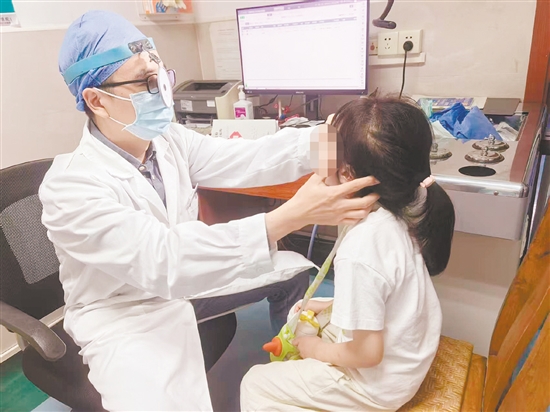 金鵬為患兒進(jìn)行檢查。