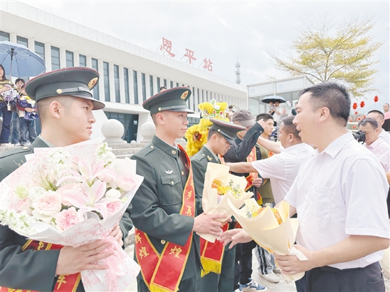 迎接隊伍工作人員為退役軍人佩戴“光榮返鄉(xiāng)”綬帶，送上鮮花。