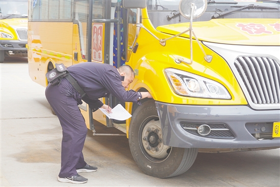 檢查組仔細(xì)對(duì)校車進(jìn)行“體檢”。