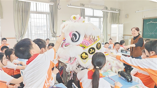 小醒獅伴隨著熱鬧的鑼鼓聲來到各班教室拜年，學生觸摸小醒獅沾沾喜氣。