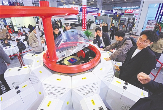 圖為當(dāng)日，參觀者在一款轉(zhuǎn)臺(tái)式多工位柔性復(fù)合機(jī)床展品旁觀看交流。新華社發(fā)