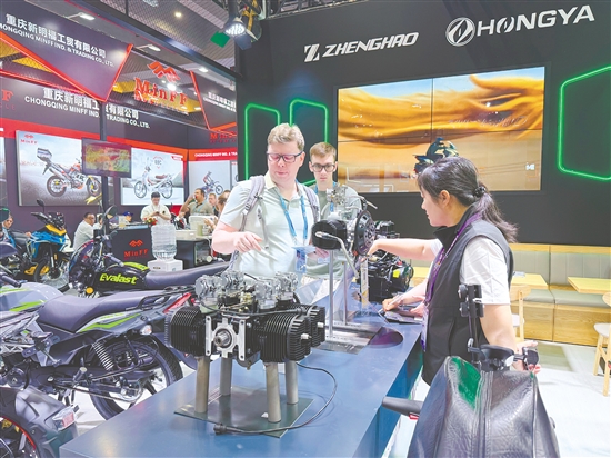 在正豪摩托展位，工作人員為外國(guó)客商介紹摩托車零部件。