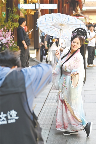 5月5日，外國(guó)游客在上海豫園商城內(nèi)體驗(yàn)古風(fēng)妝造旅拍。新華社發(fā)