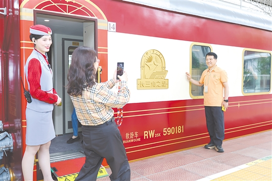 5月19日，長三角地區(qū)首趟舒適型旅游列車“長三角之星”從鐵路上海西站始發(fā)，旅客在登車前拍照留念。新華社發(fā)