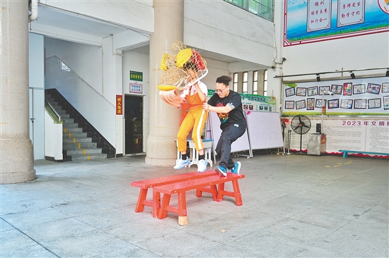 馮應(yīng)毅帶領(lǐng)學(xué)生練習(xí)移步、托舉、跳躍等獅藝動(dòng)作。