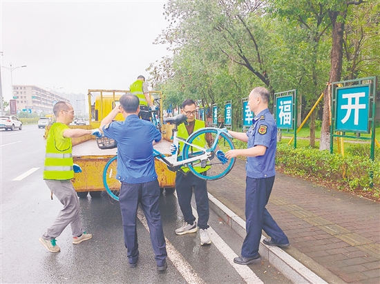 執(zhí)法人員清理違停共享單車。