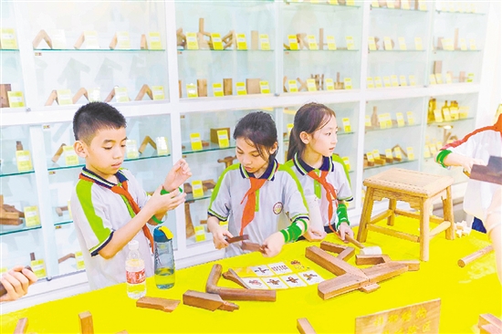 同學(xué)們現(xiàn)場學(xué)習(xí)榫卯技藝。