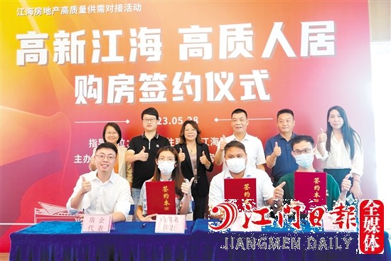 購房者代表與房企代表進(jìn)行簽約。