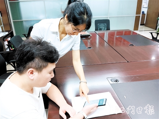 工作人員在指導(dǎo)市民線上交存住宅專項(xiàng)維修資金。陸沿任