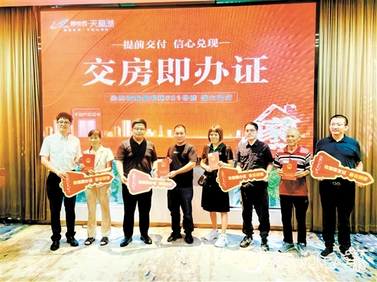 業(yè)主喜拿房產(chǎn)證和鑰匙。