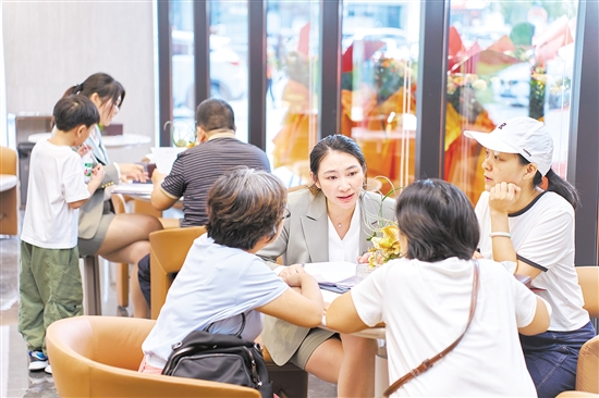 今年國慶假期，全市主要房地產(chǎn)項(xiàng)目認(rèn)購近2300套,圖為銷售人員在接待客人。