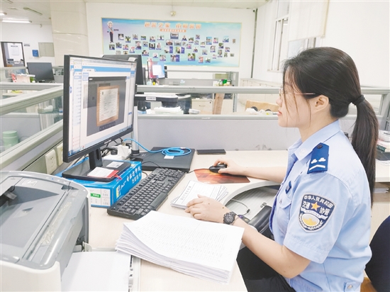 車管所網(wǎng)辦中心工作人員在對用戶提交的資料進(jìn)行審核。