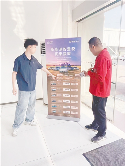 銷售人員向市民介紹優(yōu)惠政策。